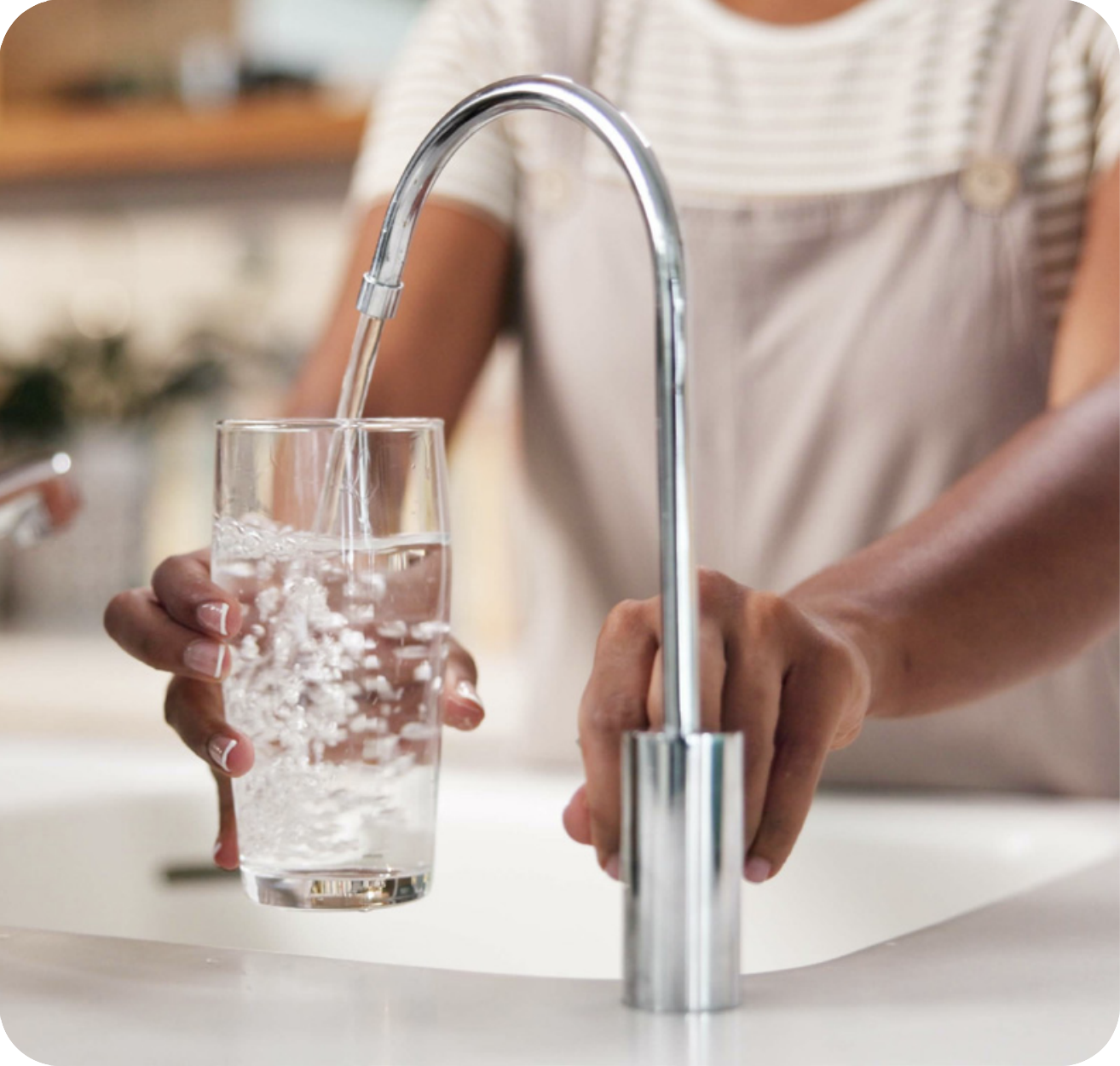 Man filling glass with water from the sink