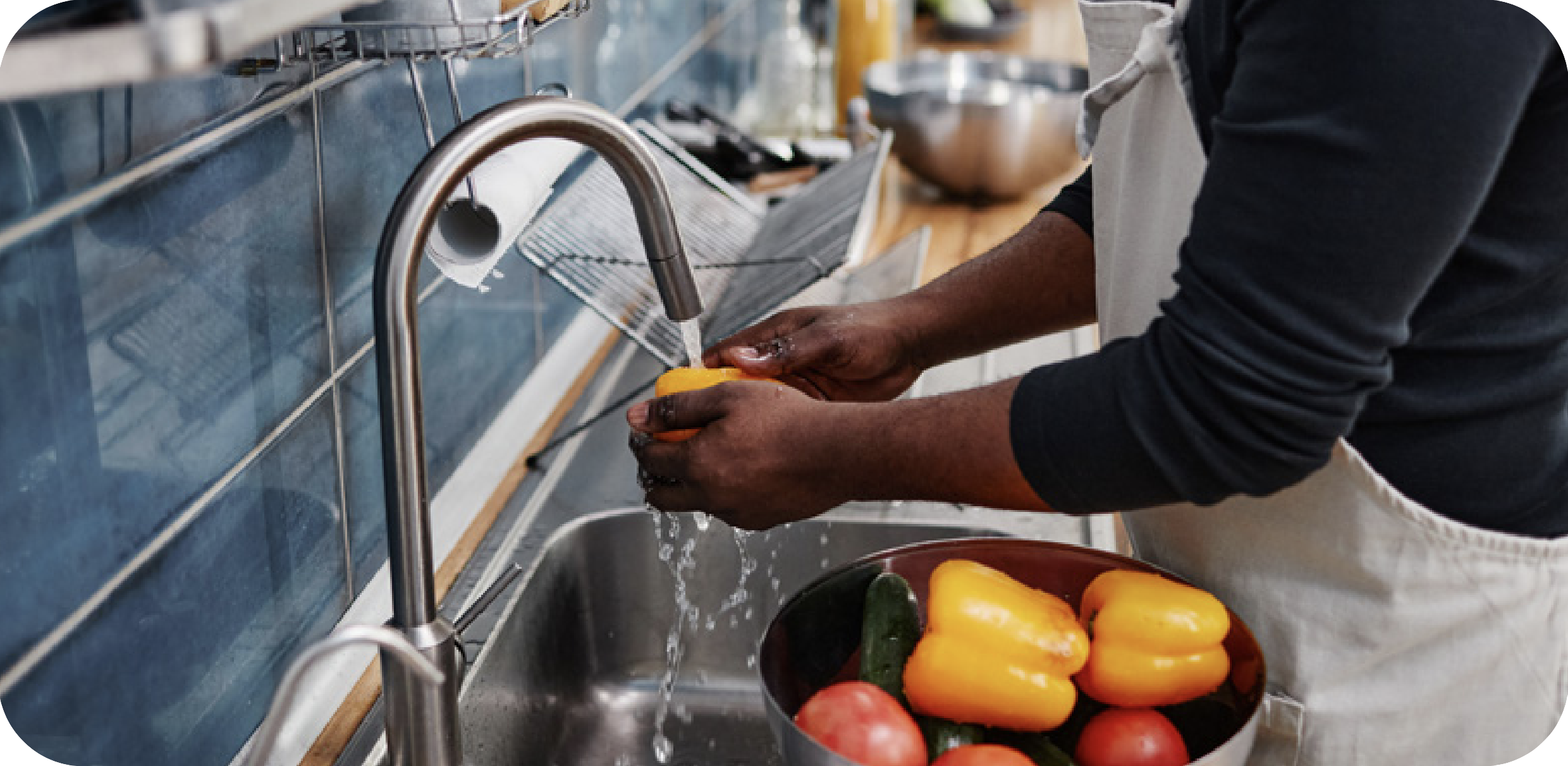 Man washing bellpeppers in the sink