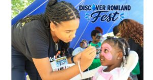 Picture of child's face being face painted during a community gathering.